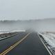 A photo of a road in the mist.
